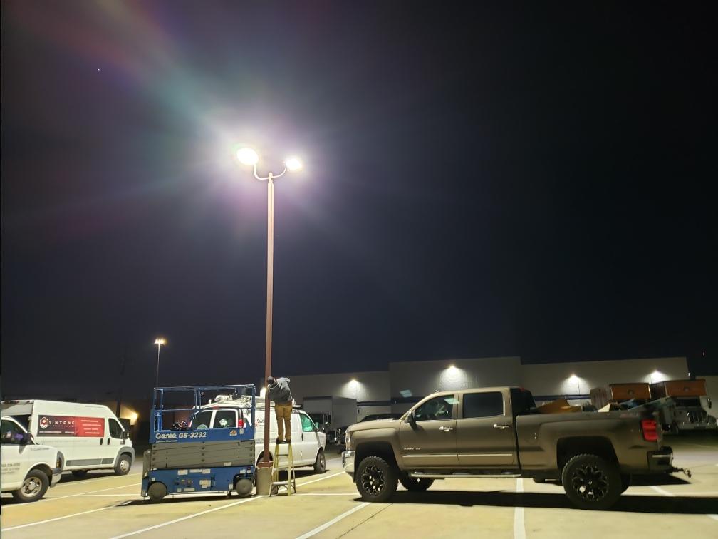 Facility technician, repairing parking light pole