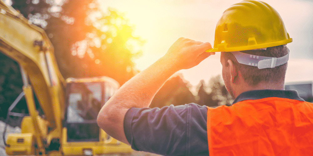 Facility technician wearing a hardhat on the job site getting ready to break ground on the next project.